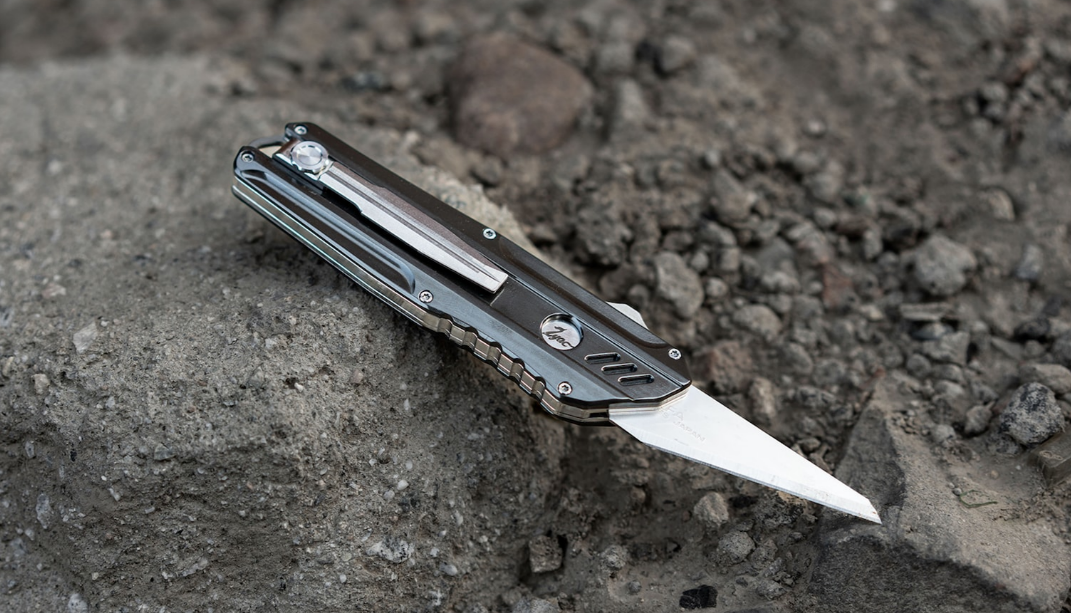 Titanium Dual-Action Automatic Utility Knife & Comb has a replaceable blade design